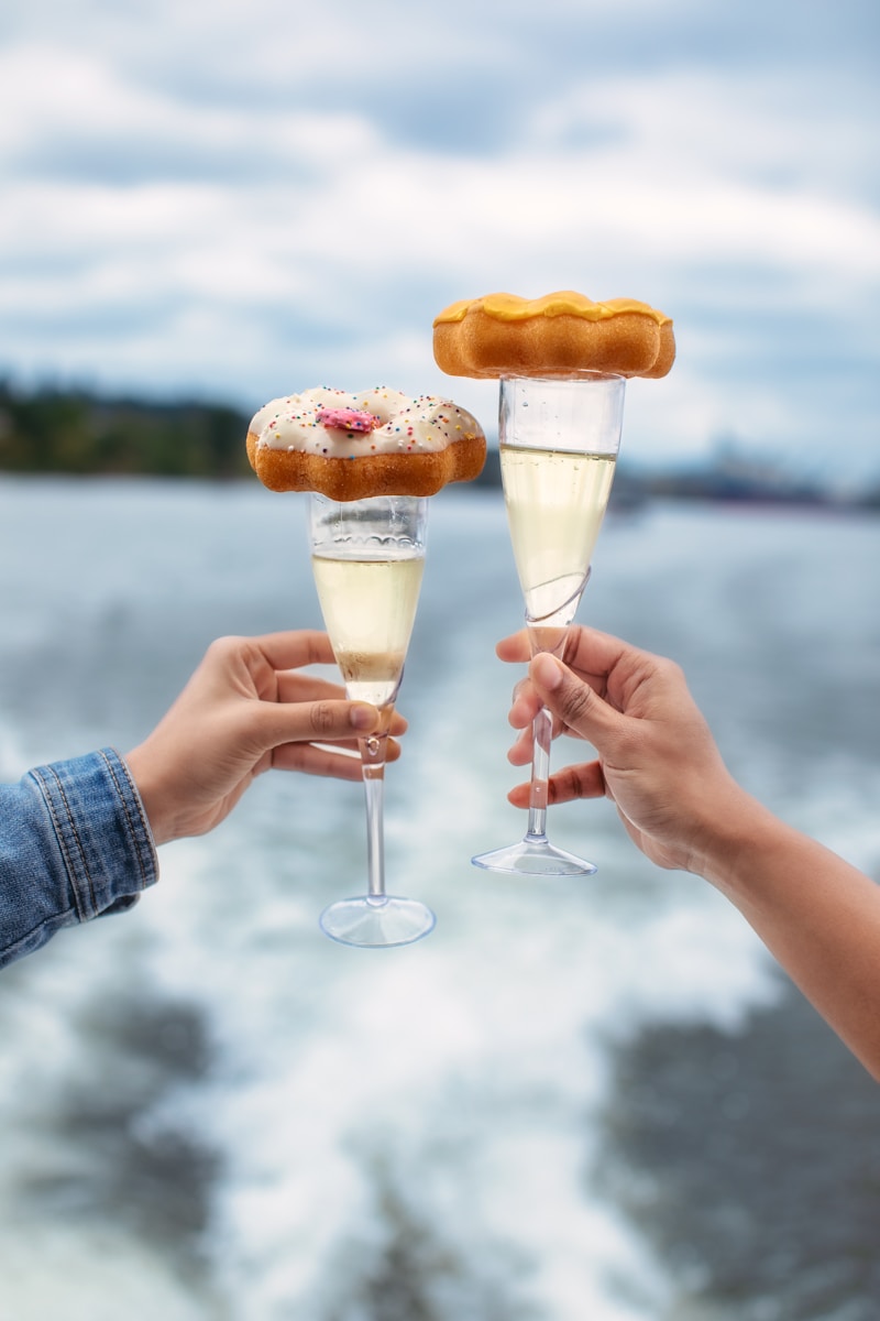 A couple of people holding wine glasses filled with food